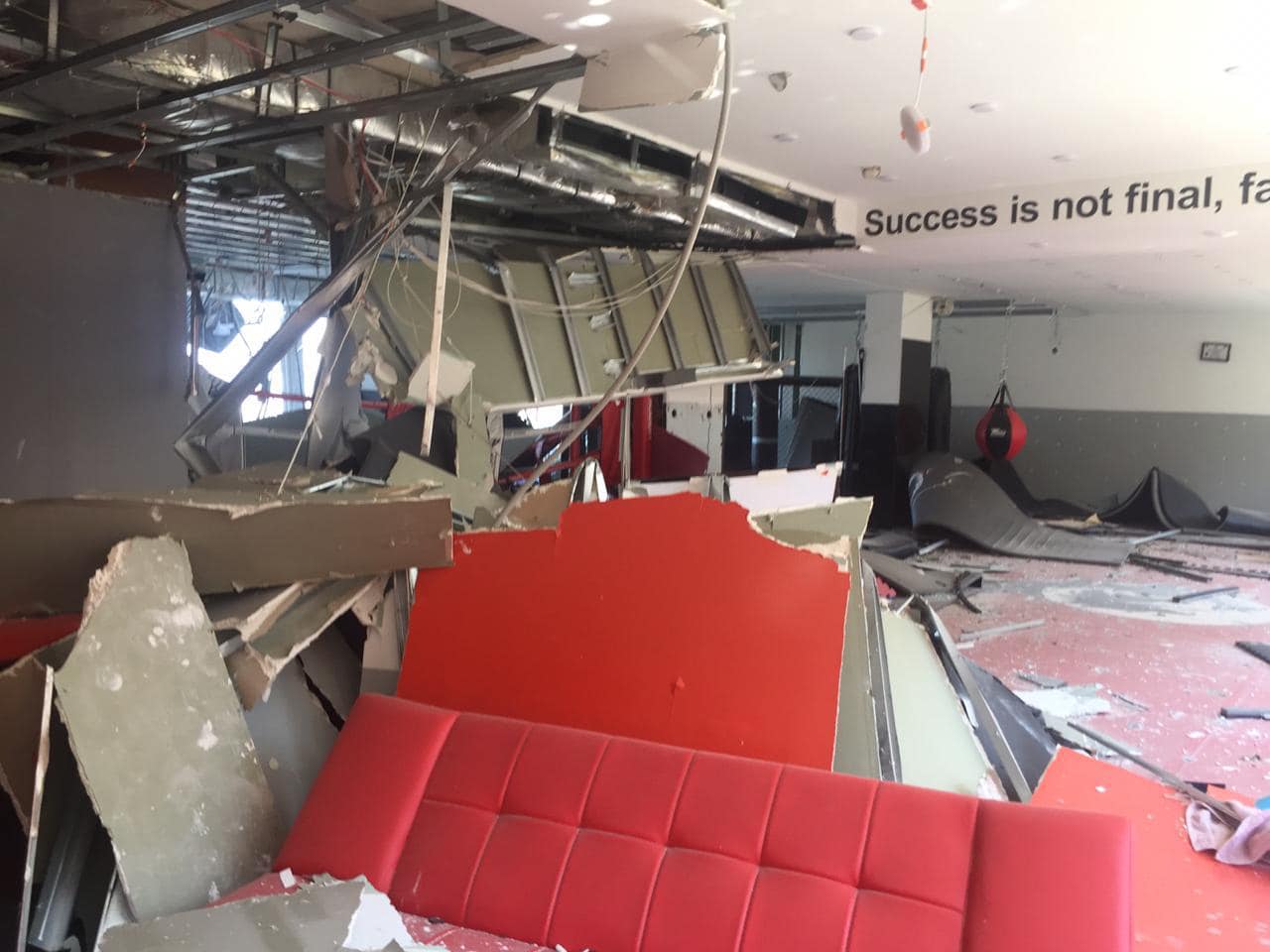 Same training hall after the blast, ceiling collapsed and furniture destroyed